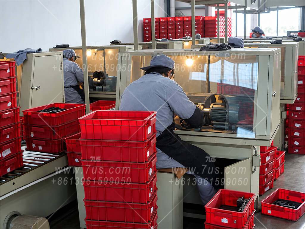 Operators working at glovebox-style grinding stations enclosed with blast-resistant glass panels