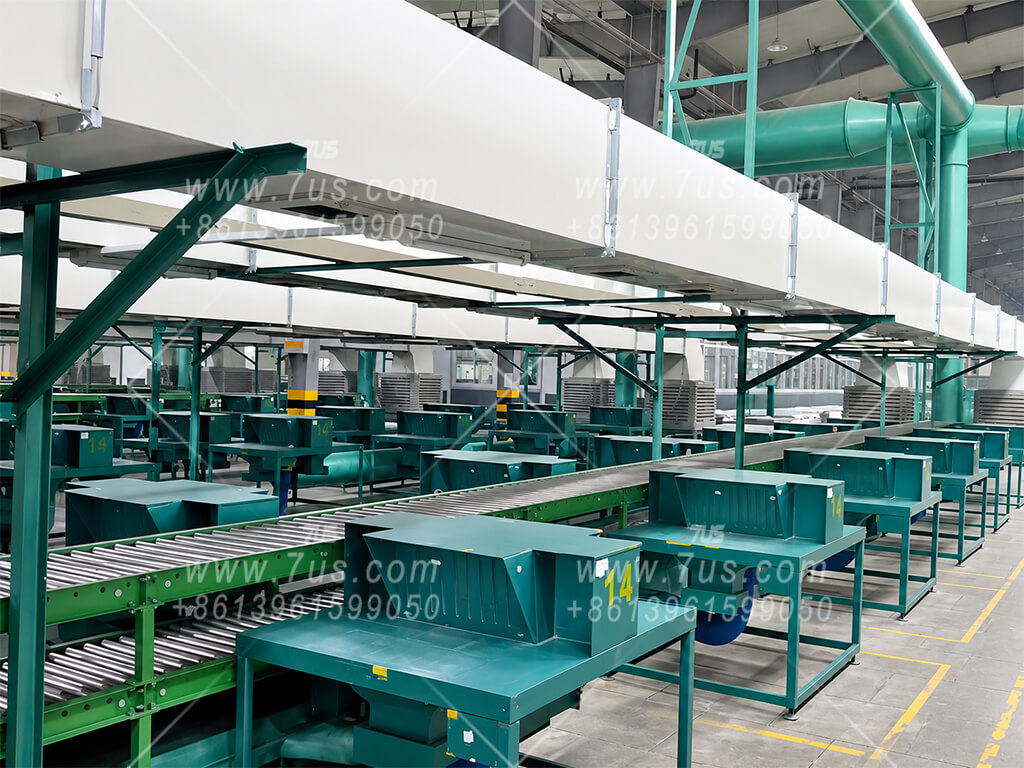 Two-operator extraction worktables with facing seating positions alongside a production conveyor