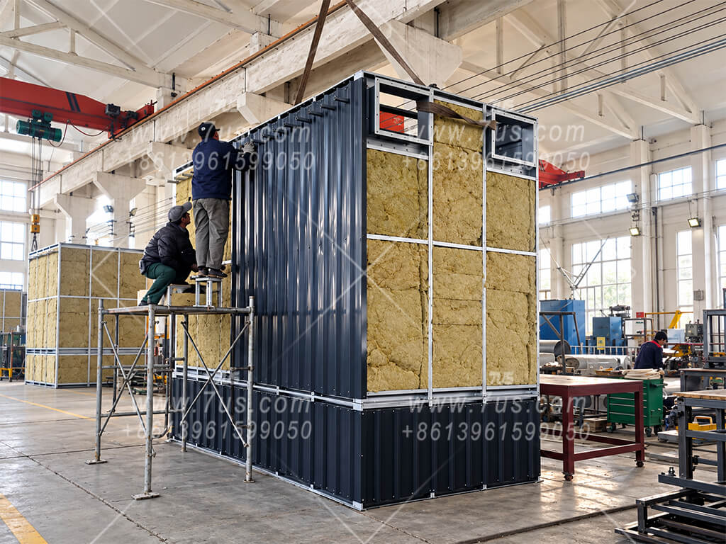 Workers installing insulation on the baghouse housing in the factory