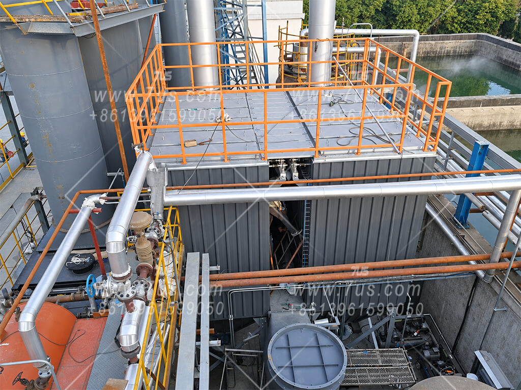 Top of the installed baghouse with orange safety railing and connected pipework