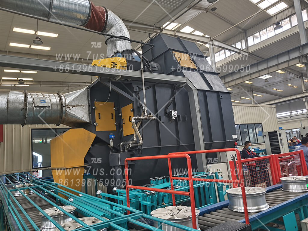 Large C-type self-induced wet dust collector installed indoors beside an automotive wheel conveyor line